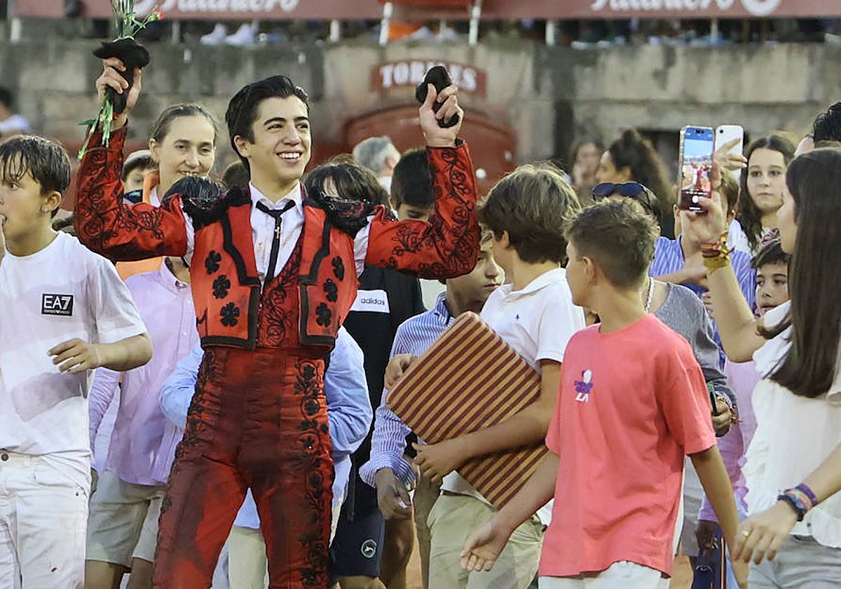 Marco Pérez, en la vuelta triunfal, rodeado de jóvenes en la plaza de toros de La Glorieta.