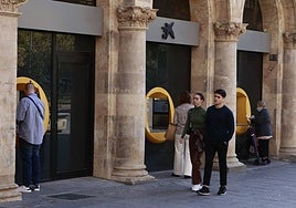 Varias personas, sacando dinero en cajeros de la ciudad.