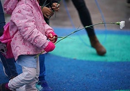 Un niño, con una flor, en un parque.