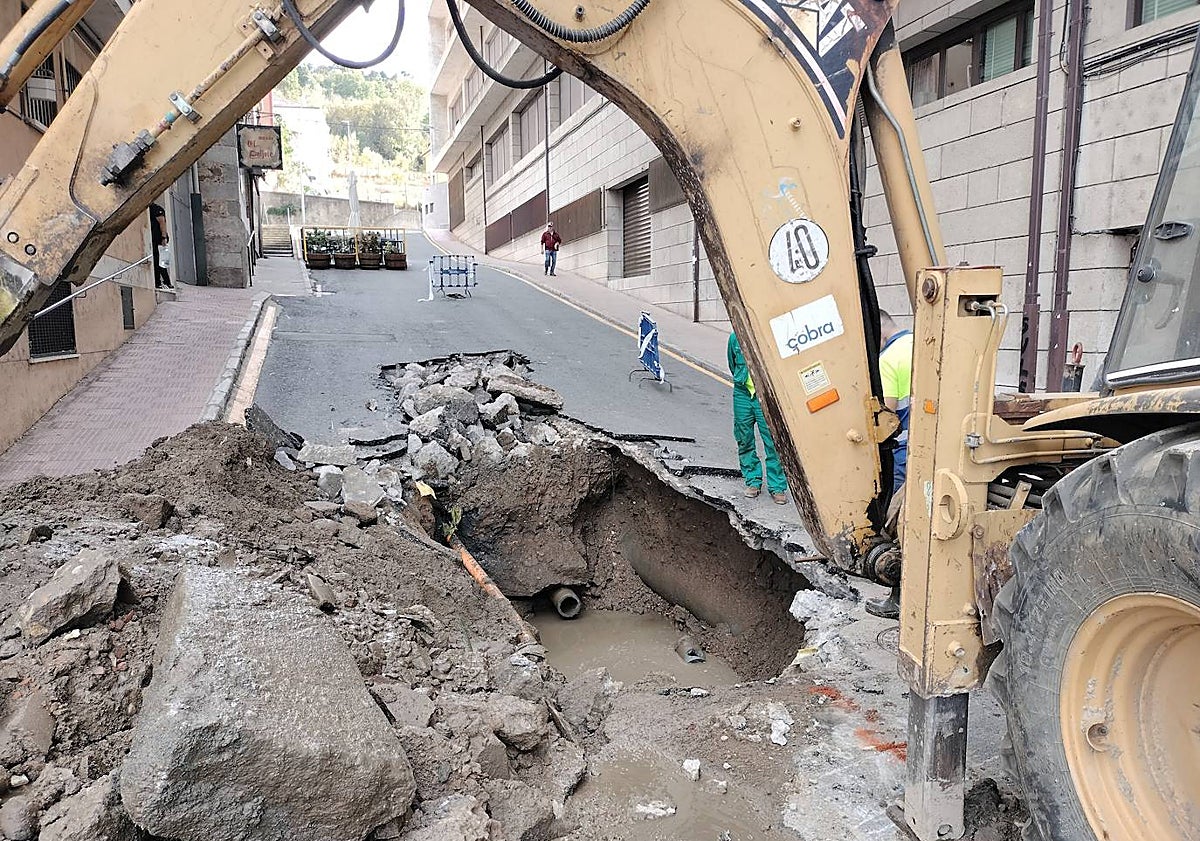 Imagen principal - Zona de la avería y vecinos en la plaza de Santa Teresa con cubos para recoger agua.