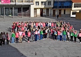 Los asistentes a la marcha rosa en Guijuelo saludaron en el gran lazo humano realizado en apoyo de los enfermos del cáncer de mama.