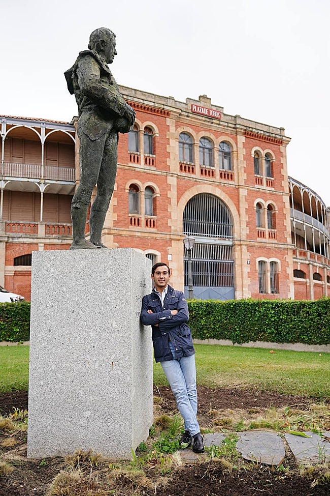 El joven torero de Cantalpino, con la estatua del maestro Capea, en los jardines de La Glorieta y, al fondo, con la puerta grande de este coso, que atravesó a hombros en cuatro ocasiones las tres últimas ediciones de la Feria: en 2023, como novillero; en el 2024, en su presentación como matador de toros, y el pasado septiembre, en dos ocasiones.