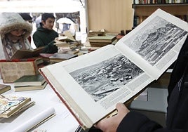 Un librero, mostrando un libro en una edición pasada.