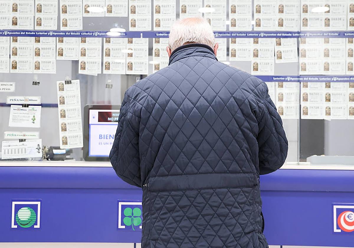 Un hombre, adquiriendo un boleto de lotería en una administración salmantina.
