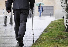 Un hombre con muleta paseando por la calle.