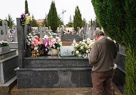 Un familiar reza ante la tumba de sus difuntos.