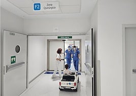 Imagen de un menor, junto a su acompañante, llegando al área quirúrgica del Hospital en un coche eléctrico.