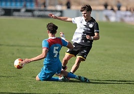 Nico Rincón trata de supera la entrada abajo de Óscar Torrellas, del Atlético de Madrid.