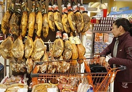 Jamones colgados para la venta en un supermercado.
