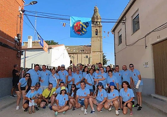 Miembros de la asociación taurina Beleguina, en el recorrido del encierro, con la iglesia de San Andrés al fondo.