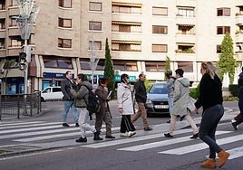 Un grupo de personas, cruzando un paso de peatones de la Puerta de Zamora.
