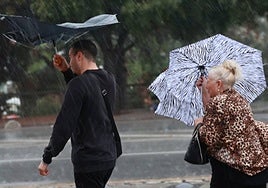 Imágenes de viandantes refugiándose de la lluvia torrencial y el fuerte viento.