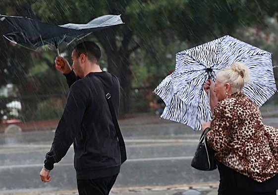 Imágenes de viandantes refugiándose de la lluvia torrencial y el fuerte viento.
