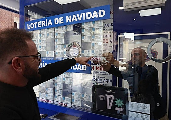 Un comprador de Lotería de Navidad selecciona un décimo en una de las administraciones de Salamanca.