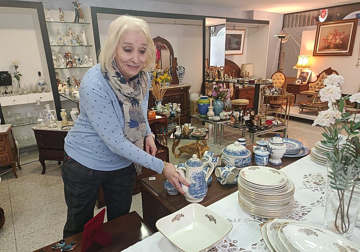 Ana Torrecilla, presidenta de la asociación, coloca una vajilla.