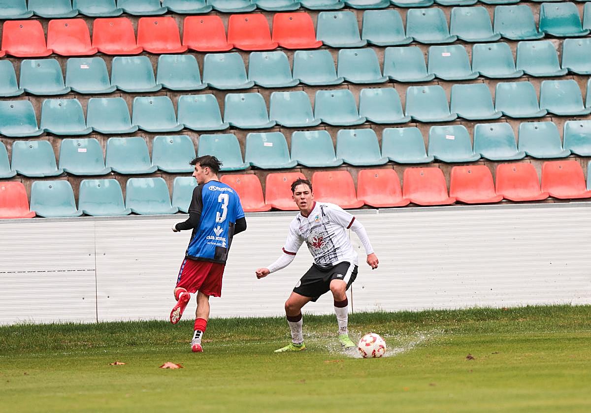 El balón en medio de un charco en el encuentro del juvenil.