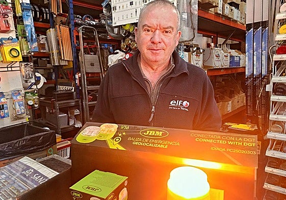 Un vendedor de una tienda de recambios de automóvil coloca algunas luces V16 obligatorias desde el 1 de enero.