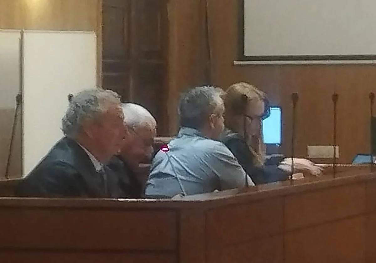 El camionero acusado, de espaldas, entre los abogados defensores.