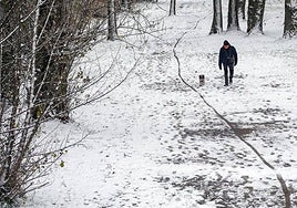 Un hombre camina por un paisaje nevado.