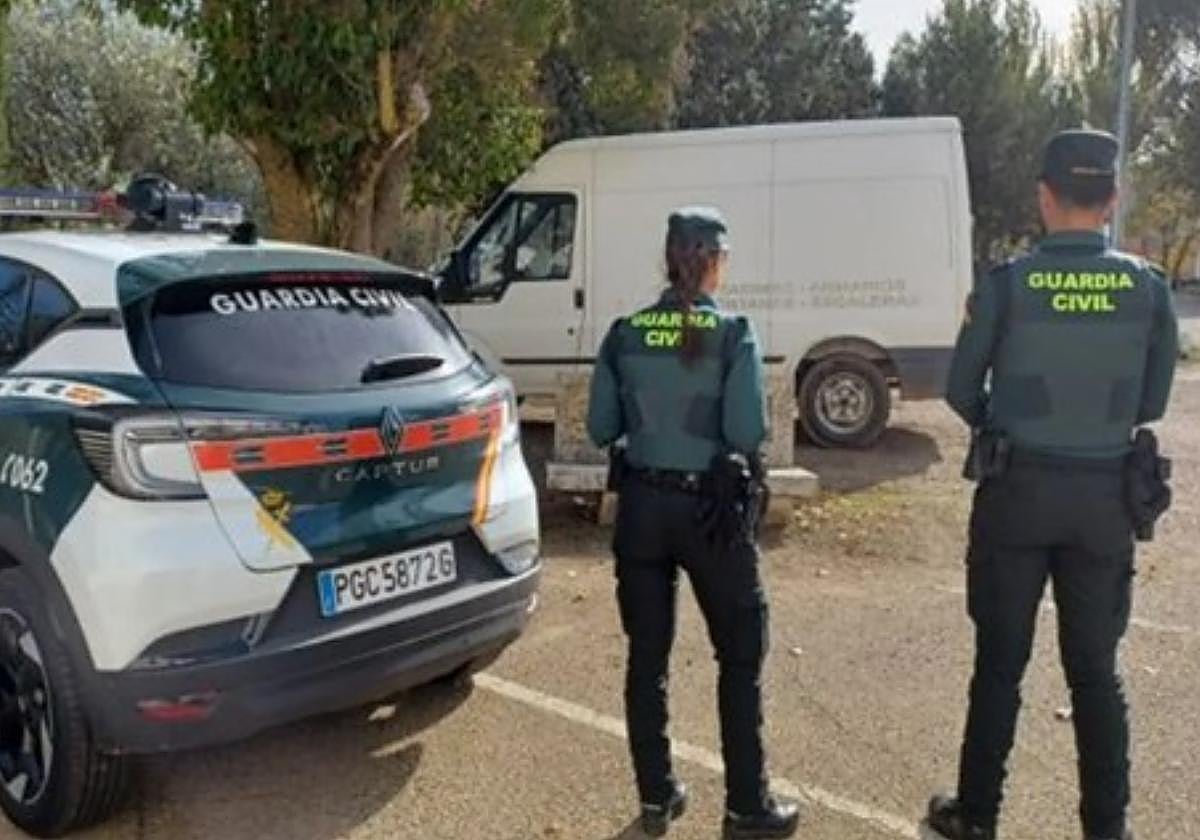 Dos agentes de la Guardia Civil, junto a la furgoneta intervenida.