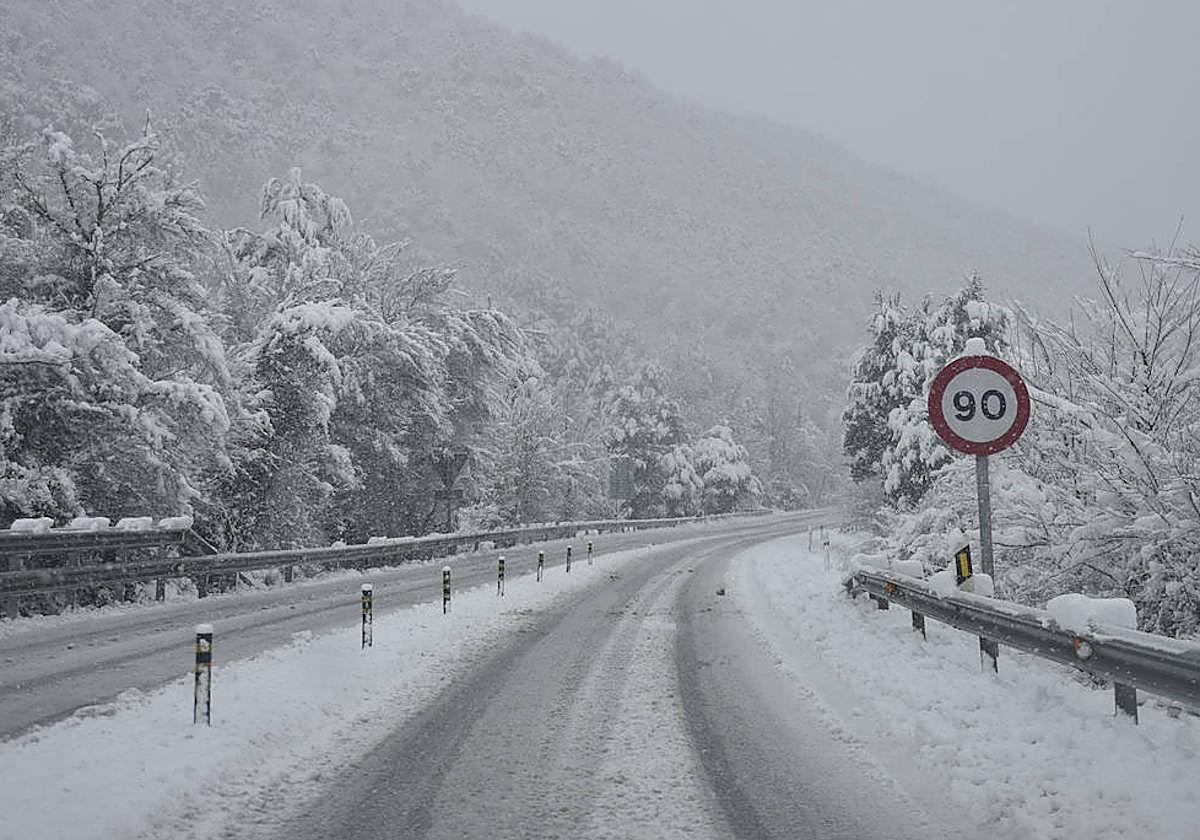 Una señal de prohibido circular a más de 90, en una carretera nevada.