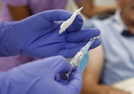 Un médico, a punto de vacunar a una persona mayor.