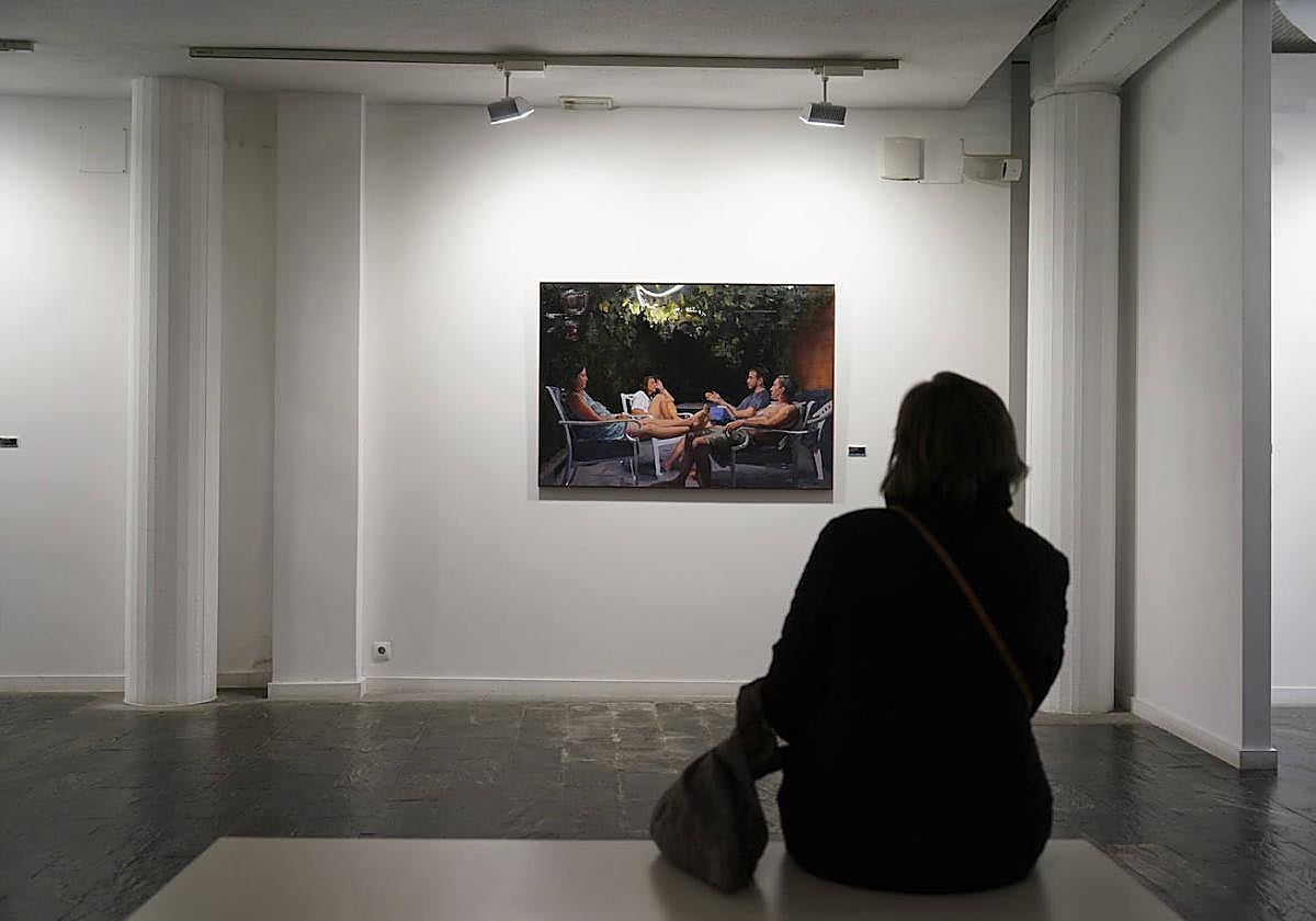 Una visitante, observando uno de los cuadros de la exposición.