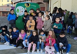 Escolares del colegio Santa Teresa de Alba de Tormes, junto al contenedor de reciclaje de vidrio.