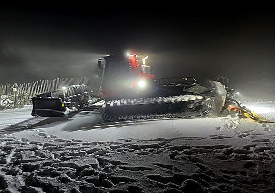 Una máquina pisapistas trabaja esta tarde noche para preparar la capa de nieve acumulada en Debutantes.