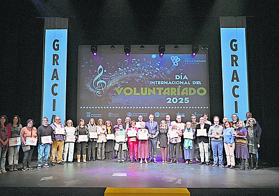 Los voluntarios reconocidos por su labor se hacen la tradicional foto de familia con el alcalde de la ciudad Carlos García Carbayo.