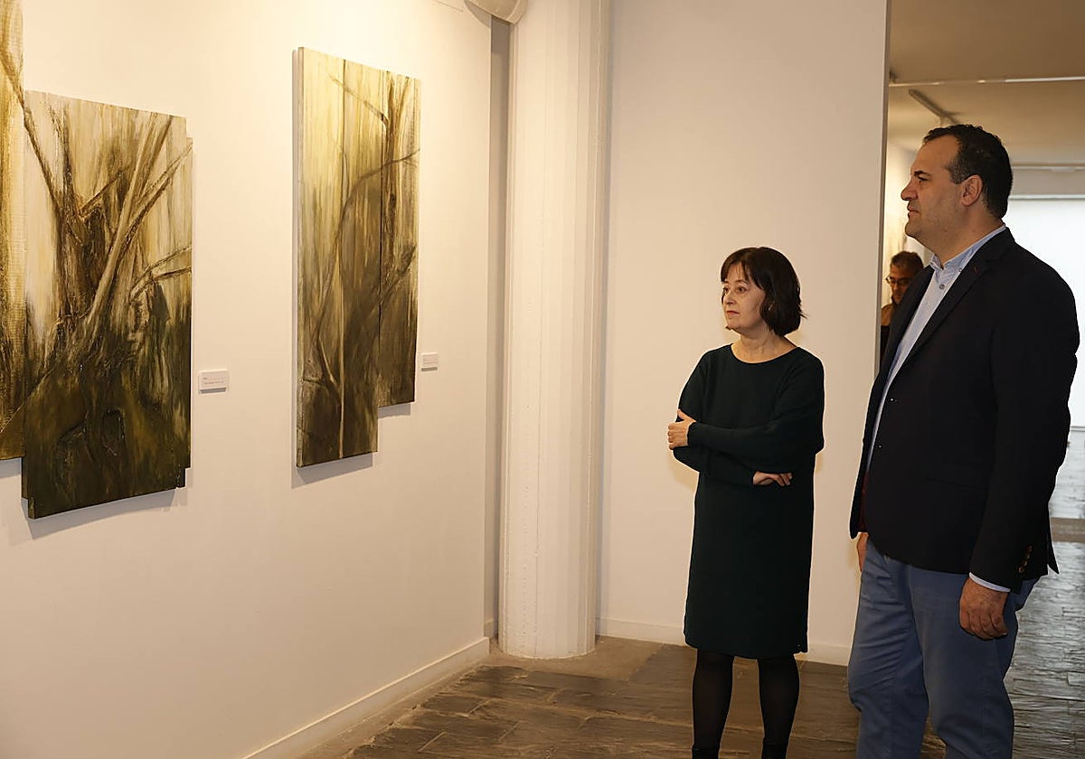 La artista Purificación del Bosque y el diputado de Cultura, David Mingo, ante algunas de las obras expuestas.