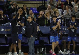 El banquillo del Perfumerías Avenida Xoborg celebra una canasta salmantina mientras Bellido camina serio.