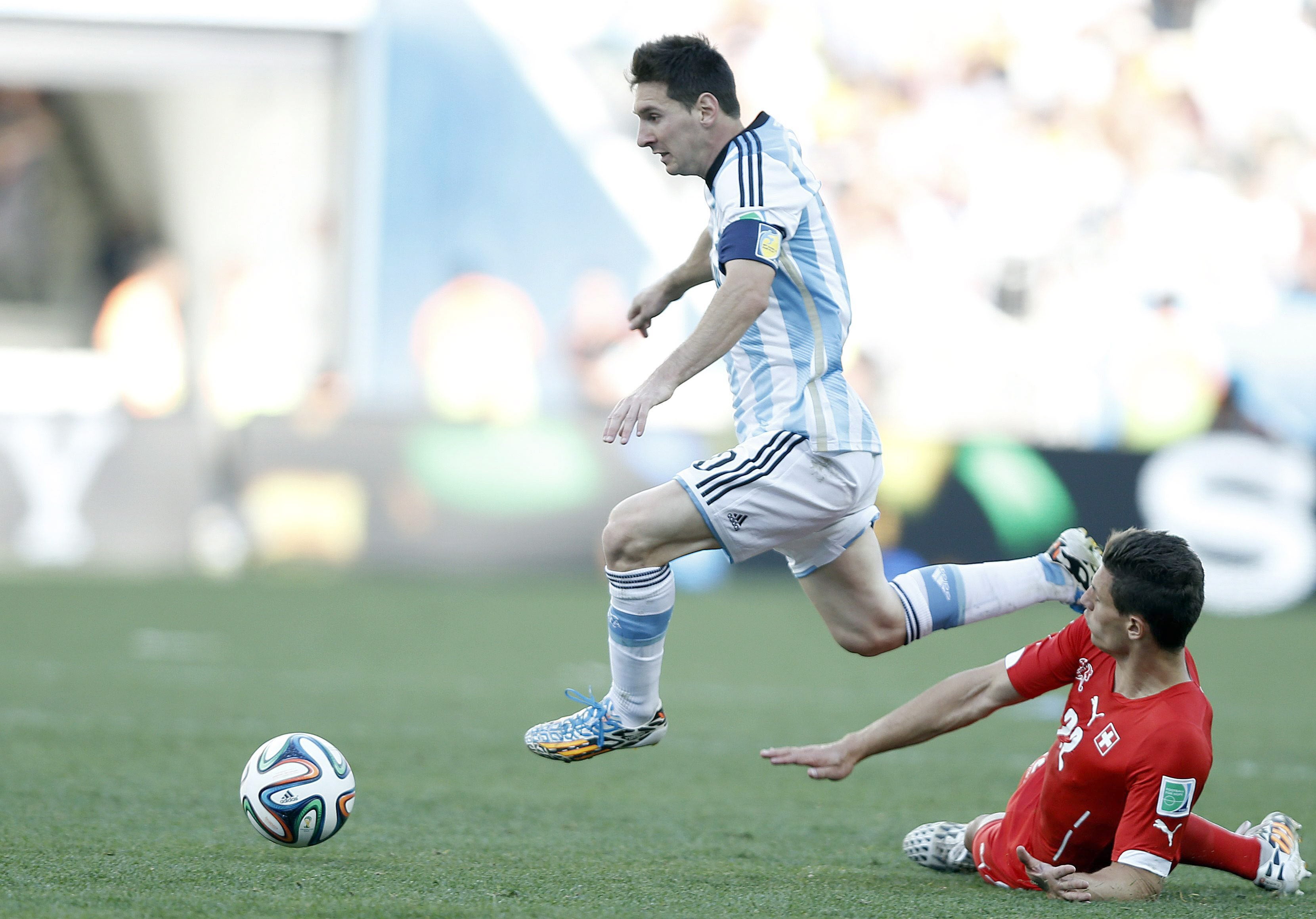 Messi se lleva el balón ante un entrada de un jugador suizo.