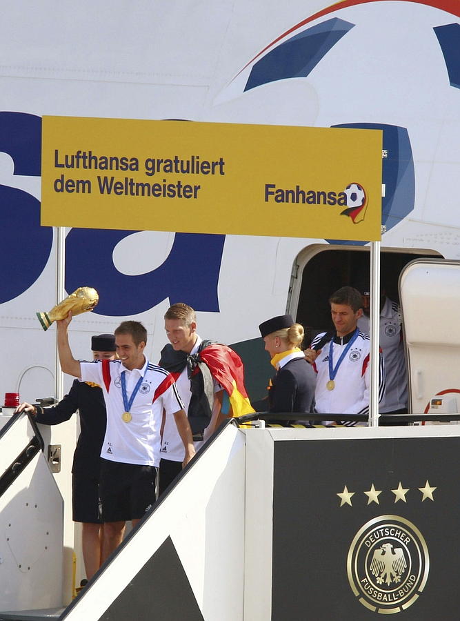 LA SELECCIÓN ALEMANA CELEBRA LA COPA DEL MUNDO CON MILES DE AFICIONADOS. El capitán de la selección alemana de fútbol, Philipp Lahm (i), desciende del avión con la Copa del Mundo de la FIFA, a la llegada del combinado al aeropuerto berlinés de Tegel a su regreso de Brasil, en Berlín.