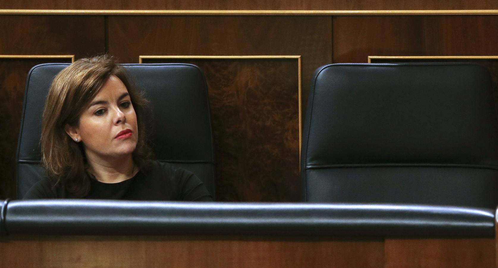 Soraya Sáenz de Santamaría escucha atentamente a Rajoy.