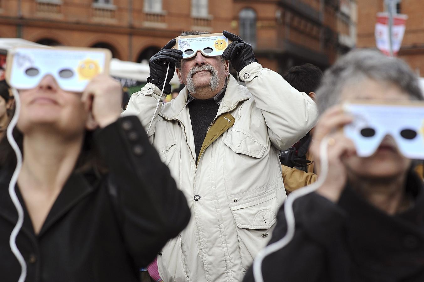 Eclipse solar 2015: Así se ha vivido. TOULOUSSE (FRANCIA). Varios personas observan el eclipse parcial de sol con el que se despide el invierno. con unas peculiares gafas.