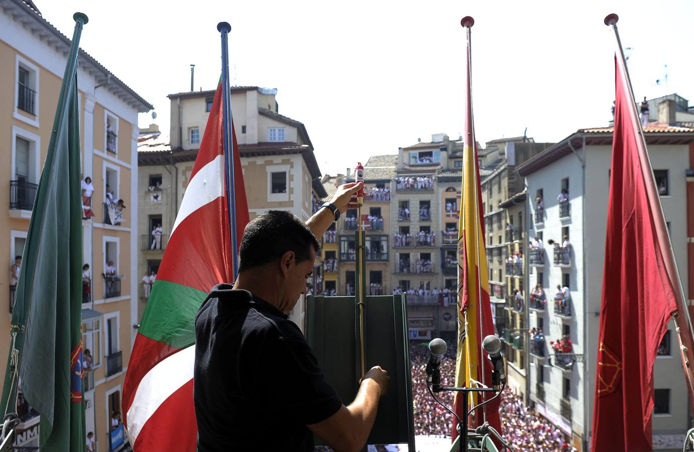 Un miembro de la pirotecnia valenciana de Caballer coloca el cohete en el balcón del Ayuntamiento de Pamplona.