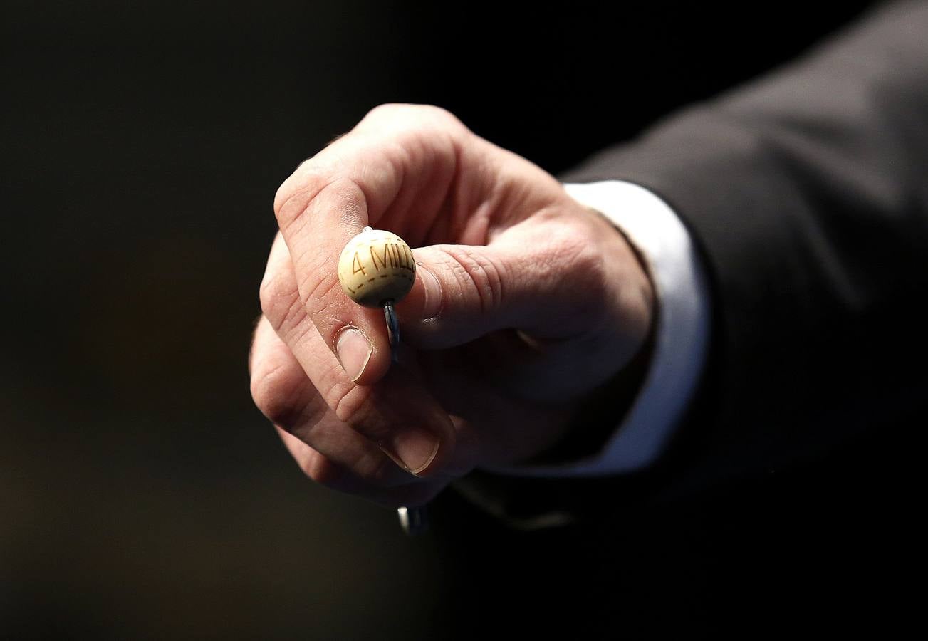 Un funcionario de Loterias y Apuestas del Estado muestra la bola con el primer premio de la Loteria de Navidad antes de introducirla en el bombo.