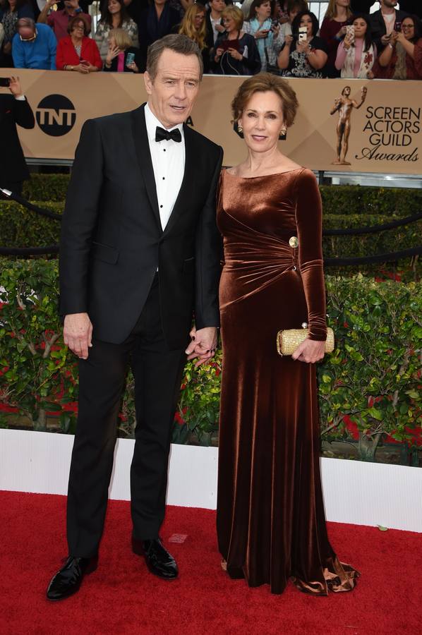 El actor Bryan Cranston y su pareja posan sobre la alfombra roja.