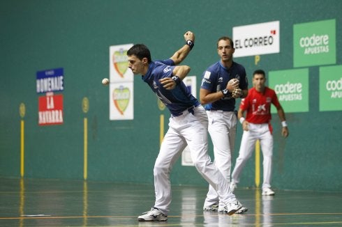 Altuna saca ante Merino II y Urrutikoetxea, al fondo, en la final de La Blanca. ::
