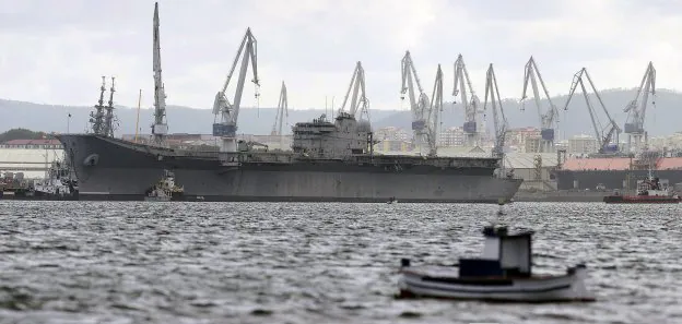 El portaaviones 'Príncipe de Asturias' es remolcado mientras abandona el Arsenal de Ferrol. :: cabalar / efe