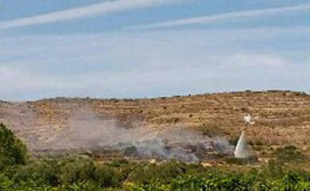 Un helibalde esparce agua en el terreno.