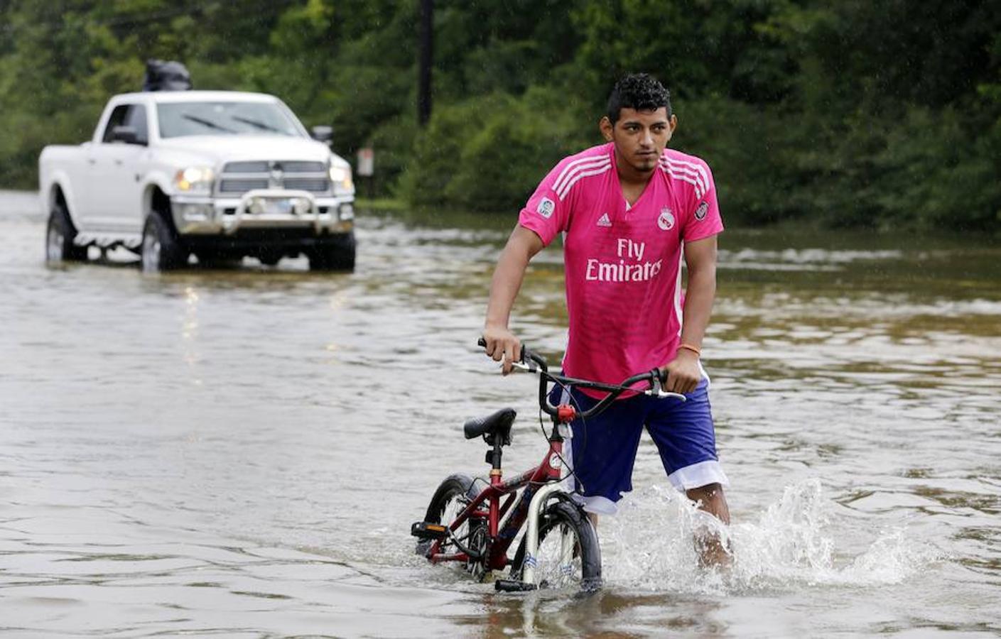 Un deportista caminando con su bicicleta en una carretera Texas 249.