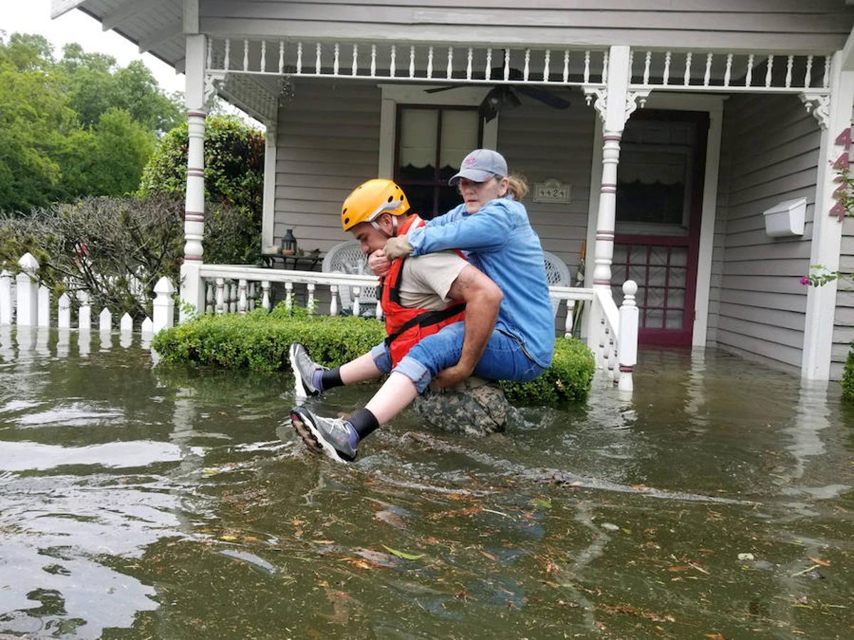 Un soldado salva a una mujer mientras realiza operaciones de rescate en áreas inundadas.