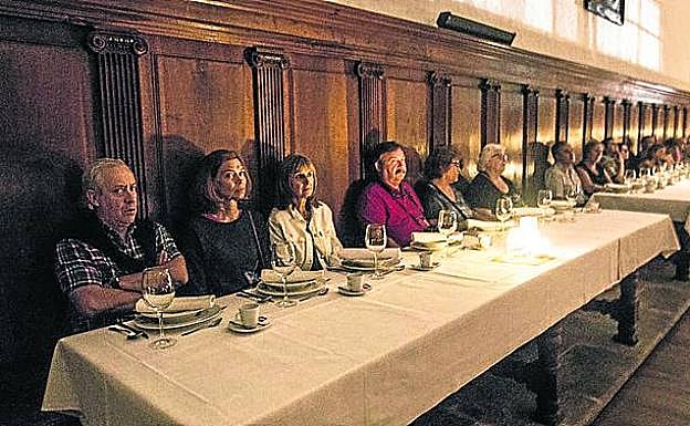 Imagen principal - El refectorio monástico, el momento de laa proyección del audiovisual en la sala de la Hispanidad y, el grupo, durante su visita a la sacristía. 