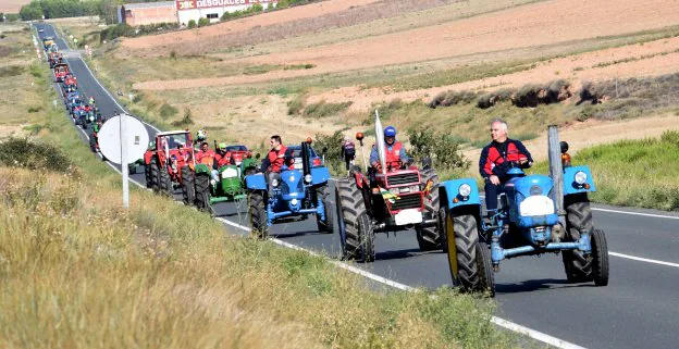 Una larga hilera de tractores clásicos circula en dirección al centro urbano de Murillo de Río Leza. :: miguel herreros