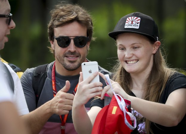 Una aficionada se saca una foto con Fernando Alonso. :: efe
