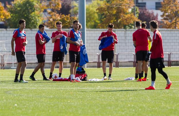 Los jugadores blanquirrojos se ponen los petos para iniciar un entrenamiento. Hoy tienen que ponerse las camisetas de ganar partidos para volver a la senda de la victoria sobre el césped del campo de Les Calayes en Villaviciosa. :: Fernando díaz