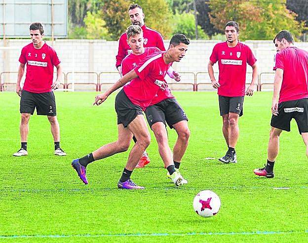 Marcos intenta llevarse el balón ante Sotillos en un entrenamiento, rodeado de compañeros. :: 