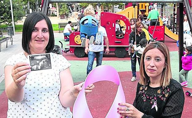 Begoña Rodríguez, que sostiene la imagen de su ecografía, y María Jesús Barreno, en el parque Gallarza. 